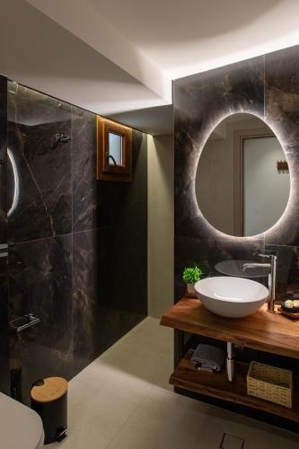 a bathroom with a sink and a mirror at Nouvelles Roses 1 in Nea Roda