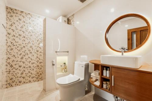 a bathroom with a toilet and a sink and a mirror at Sakabumi Home in Ngabean