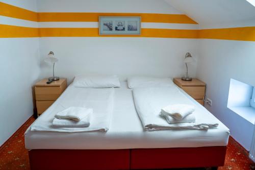 a bedroom with a white bed with towels on it at Hotel Alser in Vienna