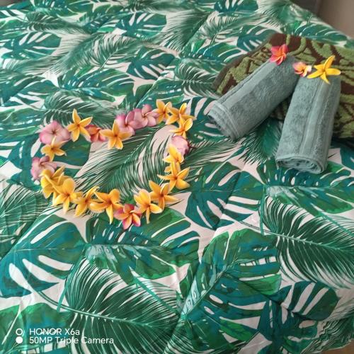 a bed with green leaves with flowers on it at Hitimahana lodge in Fare