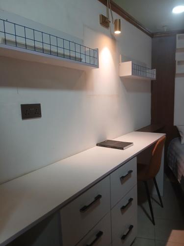 een keuken met een wit aanrechtblad en een bureau bij Premier Cabins in North Legon