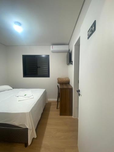 a bedroom with a bed and a tv on the wall at Pousada Vale das Bromelias Termas do Gravatal in Gravatal