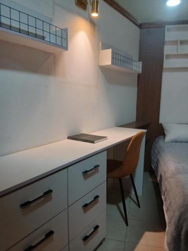 una cucina con una scrivania e un letto in una stanza di Premier Cabins a North Legon