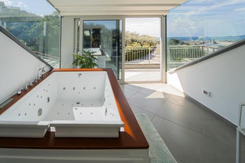 a bathroom with a bath tub and a large window at Agri Suite with jacuzzi - La Bilaia in Lavagna