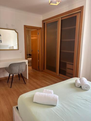 a bedroom with a bed and a desk and a chair at Pool, BBQ & Soccer Villa in Aroeira
