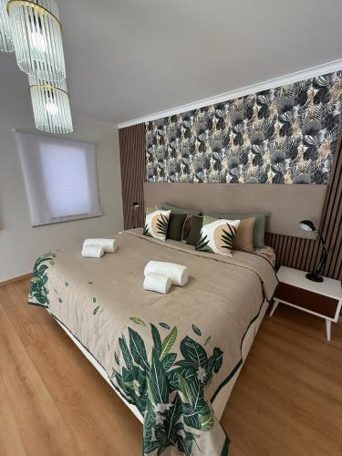 a bedroom with a large bed with a wall at Pool, BBQ & Soccer Villa in Aroeira
