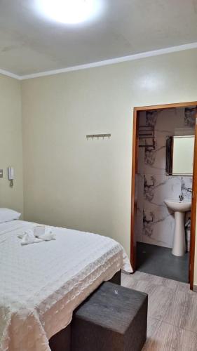 a bedroom with a bed with a sink and a mirror at Hostal Plaza Grau in Lima
