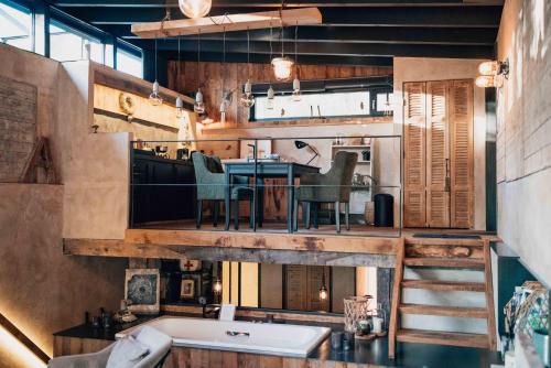 a bathroom with a tub and a table and a kitchen at Le Loft "L'Atelier", petit déj inclus in Fauvillers