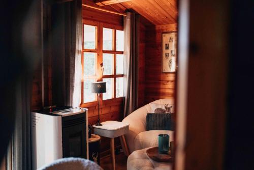 a living room with a chair and a window at Chalet d'hôtes - Les Daims - Petit déjeuner inclus in Fauvillers
