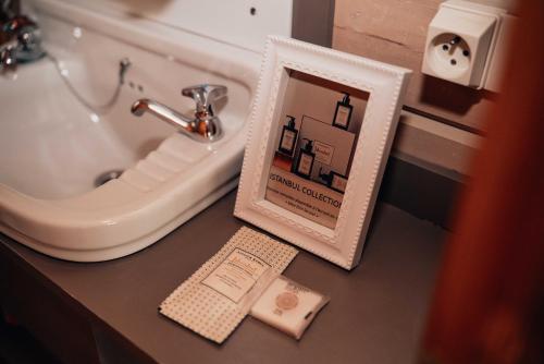 a picture frame on a counter next to a sink at Chalet d'hôtes - Les Daims - Petit déjeuner inclus in Fauvillers