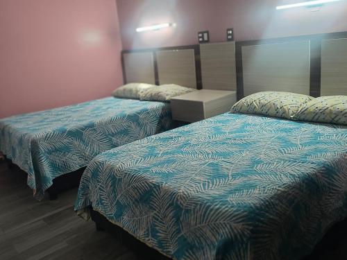 a hotel room with two beds with blue sheets at Servicios de Hospedaje in Orizaba