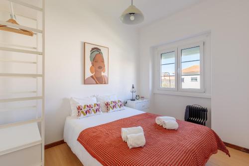 a white bedroom with a large bed with a red blanket at Lovely Apartment to Stay in Lisbon