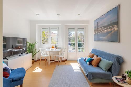 a living room with a blue couch and a table at Lovely Apartment to Stay in Lisbon