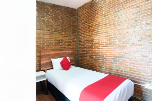 a bedroom with a brick wall and a bed at Hotel de Guadalupe in Puebla