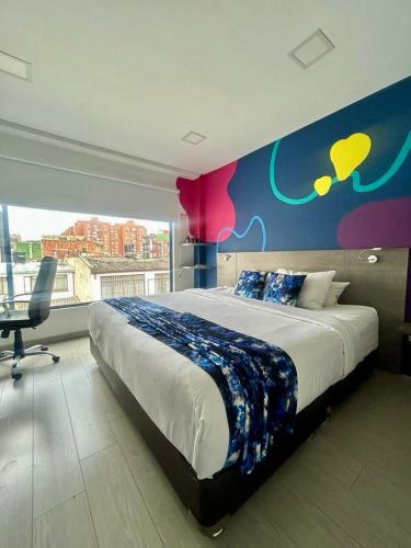 a bedroom with a large bed with a colorful wall at Agora Suites Hotel, Check-in digital fácil con atención virtual 24h in Bogotá