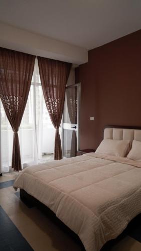 a bedroom with a large white bed with windows at Sheba Palace Apartment in Addis Ababa