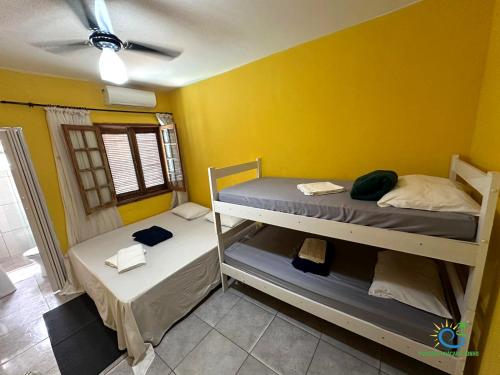two bunk beds in a room with a yellow wall at Pousada Chácara Sonho in Hortolândia