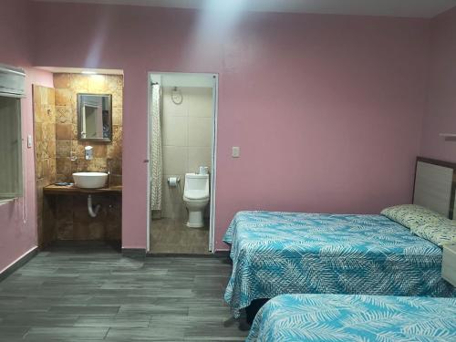 a hotel room with two beds and a bathroom at Servicios de Hospedaje in Orizaba