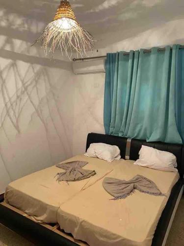 a bed in a room with a blue curtain at Aghir DJERBA Erdgeschosswohnung in Al Ḩaddādah