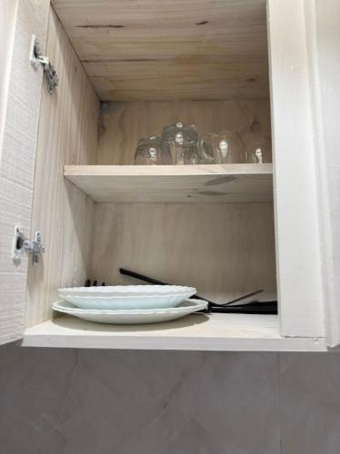 a plate and utensils sitting in a cabinet at merlomar1 in Merlo