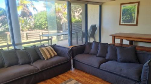 a living room with two leather couches and a table at Apartment In Paradise in Hawks Nest