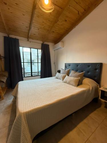 a large bed in a bedroom with a wooden ceiling at merlomar1 in Merlo