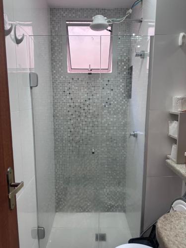 a bathroom with a glass shower with a window at AP ALPHA 5 STAr in Vespasiano