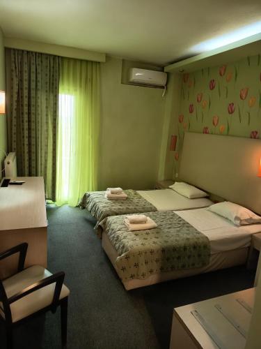 ein Hotelzimmer mit zwei Betten und einem Fenster in der Unterkunft SKG Assembly Β&Β Hotel in Thessaloniki
