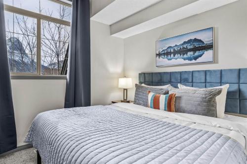 a bedroom with a large bed and a window at Mystic Springs #108 - Hot Tub and Pool, Pets managed by Little Sister Getaways in Canmore