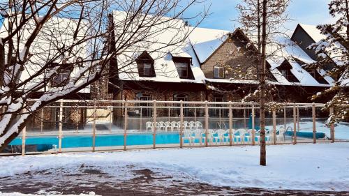 a house with a fence in the snow at Mystic Springs #108 - Hot Tub and Pool, Pets managed by Little Sister Getaways in Canmore
