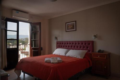 a bedroom with a red bed with a red blanket at Alto Colonial in Salta