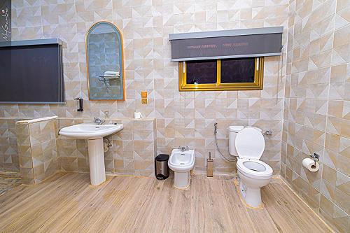 a bathroom with a toilet and a sink at Coconut Residence & Spa in Kololi
