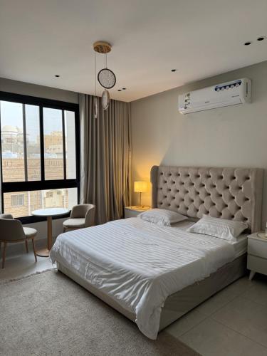 a bedroom with a large bed with a large window at BEhouse, in Jeddah