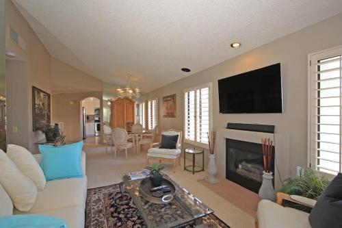 a living room with a fireplace and a flat screen tv at Balcony-Views-Country Club Living-VV667 in Palm Desert