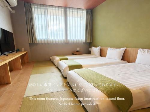 a hotel room with two beds and a television at Kansai Airport Hotel Pine Villa in Kansai International Airport