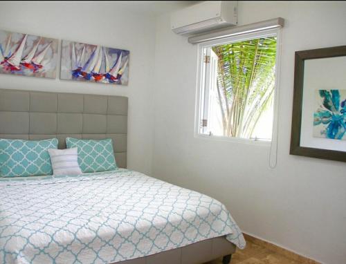 a bedroom with a bed and a window at Jobos Beach House - Steps from the beach! in Isabela