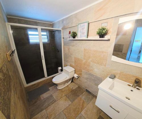 a bathroom with a toilet and a sink at Jobos Beach House - Steps from the beach! in Isabela