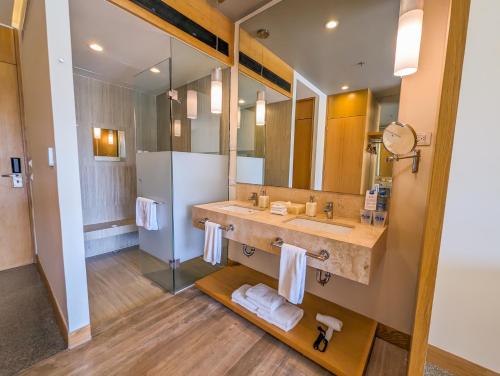 a bathroom with a sink and a large mirror at Hotel Mio Vallarta - Adults Only in Puerto Vallarta