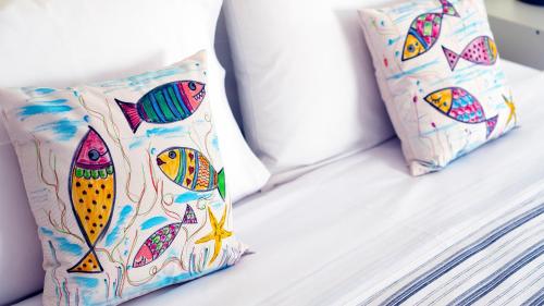 two pillows are sitting on a bed at Kalimera Aegina in Agia Marina Aegina