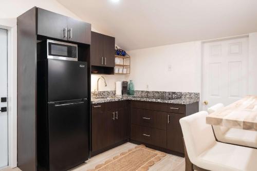 a kitchen with a black refrigerator and brown cabinets at The Margaret Suite in Key West