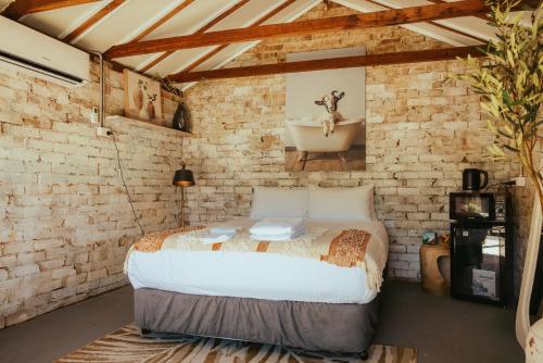 a bedroom with a large bed in a brick wall at Montblu at Echo Point in Katoomba