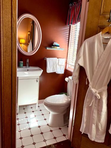 a bathroom with a toilet and a sink and a mirror at Cecil Bacon Manor in Seattle