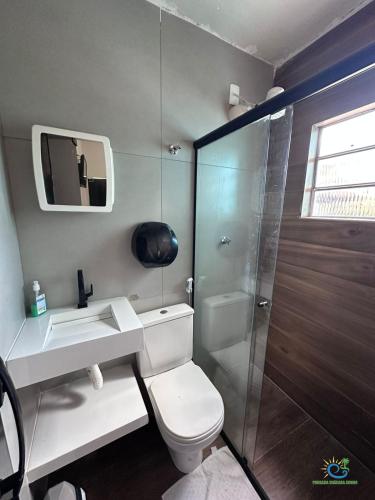 a bathroom with a toilet and a sink and a shower at Pousada Chácara Sonho in Hortolândia