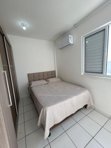 a small bedroom with a bed and a window at Apartamento com vista imperdível in Laguna