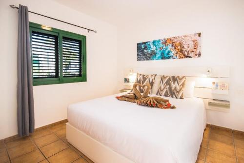 a bedroom with a white bed and a window at Casa Bodega Coco in Puerto del Carmen
