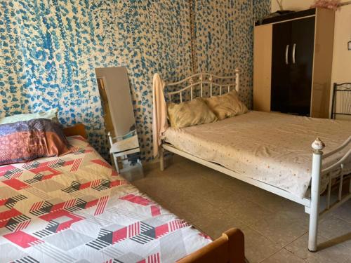 a bedroom with two beds in a room with wallpaper at Porto Calheta in Calheta