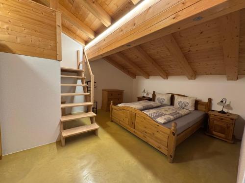 a bedroom with a wooden bed and a staircase at Ferienwohnungen Kieferbachtal in Kiefersfelden