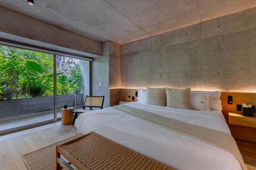 a bedroom with a large bed and a large window at Lulu Condesa by Capitalia in Mexico City