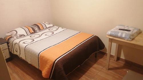 a bed in a room with a wooden table at La Posada in Cajamarca