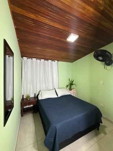 a bedroom with a blue bed with a wooden ceiling at Aquarium Rooms in Floridablanca